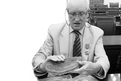 梅森教授在展示三叶虫化石模型。